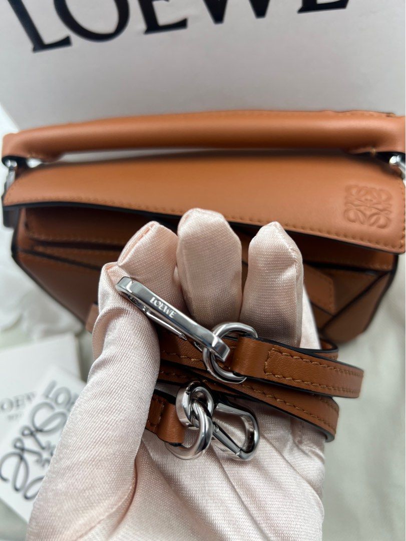 ⚜️Loewe Mini puzzle bag (Category: Luxury Bags & Wallets) located in Makati City. Submitted by 90sangel (Listing ID 1394593407, Image 2). Description: •Item: Loewe mini puzzle bag in brown/tan⚜️🍁🍂👜 •Size: Mini, so cute! •Condition: Hard to find, gently used and good as new! *This includes box, dustbag cards & paperbag. .