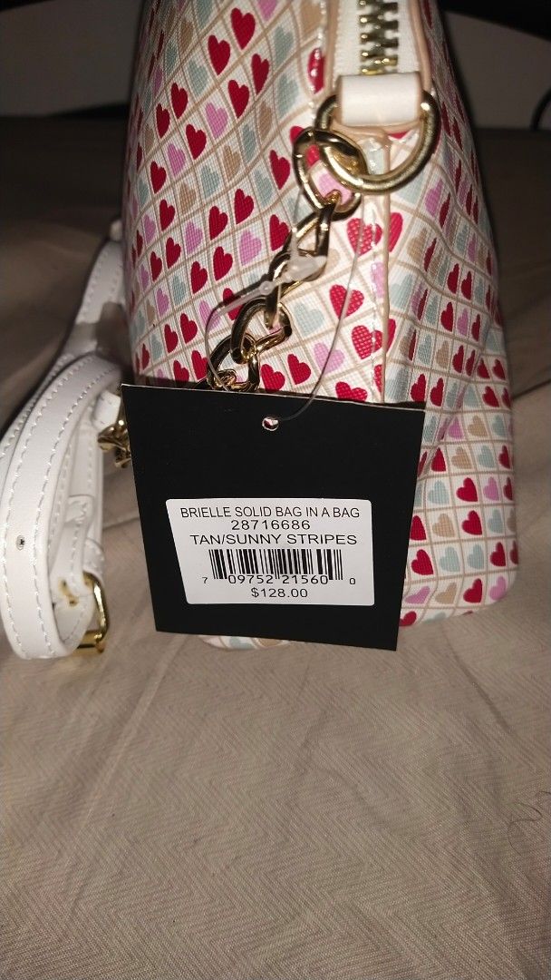 Nanette Lepore Heart Print Bag (Category: Cross-body Bags) located in Las Pinas. Submitted by younggem.d97325 (Listing ID 1394426691, Image 3). Description: Nanette Lepore bag features a heart print design. It has a gold chain strap and a white strap. The bag has a zipper closure and an interior pocket. The tag indicates the style name is "Marble Solid Bag in a Bag" and the color is "Tan Sunny Stripes". Price: ₱750 fixed Issue: Has a stain but is