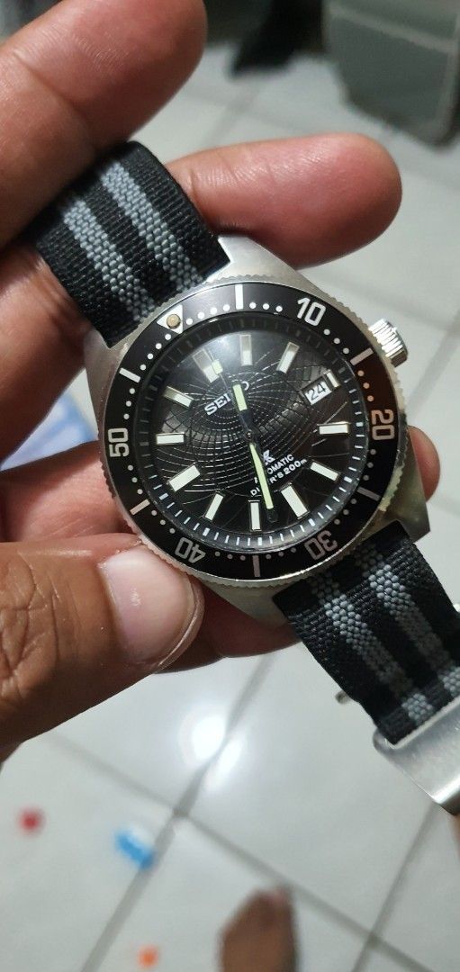 Seiko Mod 62mas Watch with Black Dial (Category: Luxury Watches) located in Lapu Lapu. Submitted by watchenthusiast4444 (Listing ID 1394430704, Image 1). Description: - Seiko watch with a black dial Seiko nh35 Automatic movement - Luminous hands and markers - Rotating bezel - Black and gray striped NATO strap - Stainless steel case - Date display at 3 o'clock.