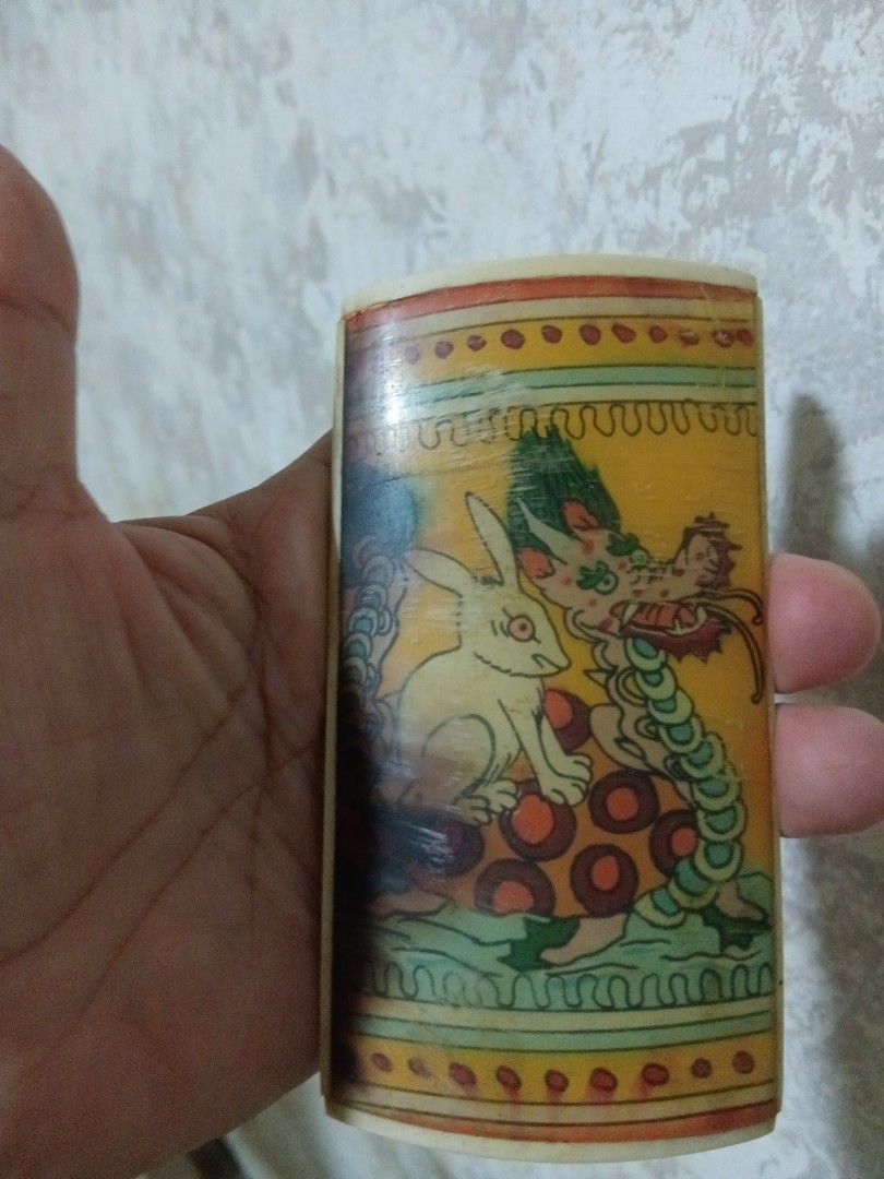 Vintage IVO bone Dragon and Rabbit Decorated display (Category: Vintage Collectibles) located in Quezon City. Submitted by threetwotwo2ndaccount (Listing ID 1394408362, Image 2). Description: - Vintage ivo bone dragon and rabbit artwork. - Cylindrical shape with a curved top. - Features detailed, vibrant artwork. - Made of a light-colored material (possibly bone). - Unique and decorative design..