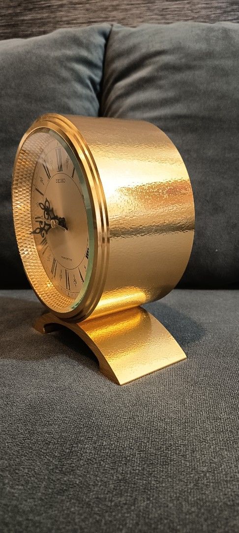 Vintage Seiko Transistor mantle clock 1970's (Category: Clocks) located in Binangonan. Submitted by retrovintagesourceph (Listing ID 1394485745, Image 3). Description: - Vintage Seiko table clock - Gold-tone finish - Round face with Roman numeral hour markers - Black hands - Marked "SEIKO TRANSISTOR" - Gold-tone base - Battery-operated - Approximately 20cm wide and 20cm tall.