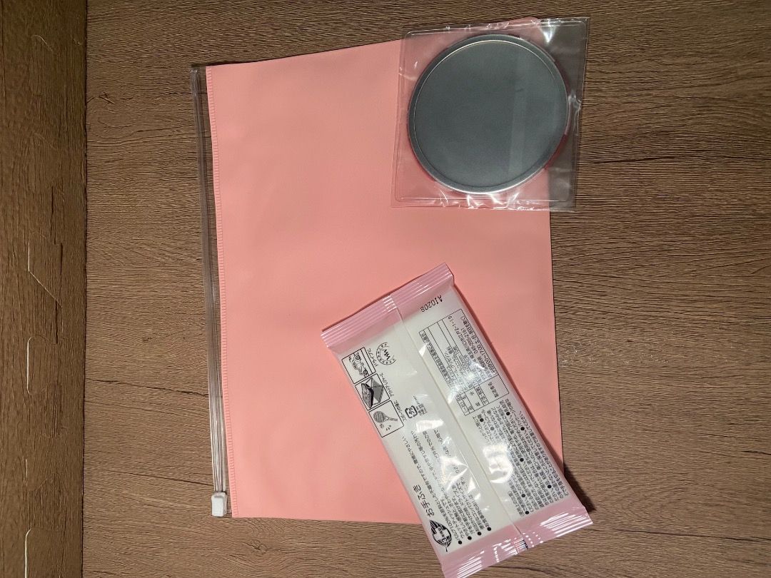 Makeup pouch free mirror and wipes (Category: Face Care) located in Taguig. Submitted by Rare_findsmnl (Listing ID 1394728830, Image 2). Description: - Includes a makeup remover pad (round, gray, sealed). - Features a sample packet with Japanese text and pink accents. - Packaged in a stylish pink zippered pouch..