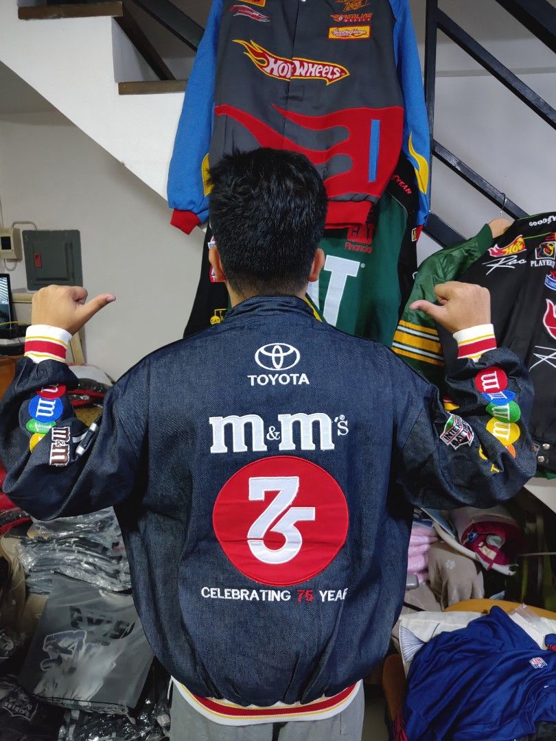 M&M's Racing Jacket (Category: Coats, Jackets and Outerwear) located in Pandi. Submitted by yanyan_apparel.store08 (Listing ID 1394647445, Image 2). Description: Remake Remake - Dark denim jacket - Features patches: M&M's, Toyota, Interstate Batteries - Celebrates M&M's 75th anniversary - Front zipper closure - Ribbed cuffs with M&M's branding - Large M&M's and Toyota logos on back - Number 18 on sleeves.