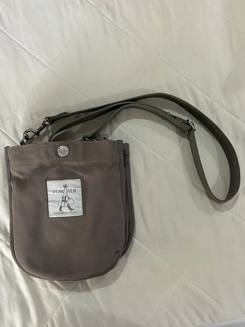 Porter International Shoulder Bag (Category: Shoulder Bags) located in Manila. Submitted by decluttteringz (Listing ID 1394611858, Image 1). Description: - Porter International shoulder bag - Main compartment with zipper closure - Adjustable shoulder strap - Small inner pocket - Neutral color - Porter International logo on front - Button closure on front.