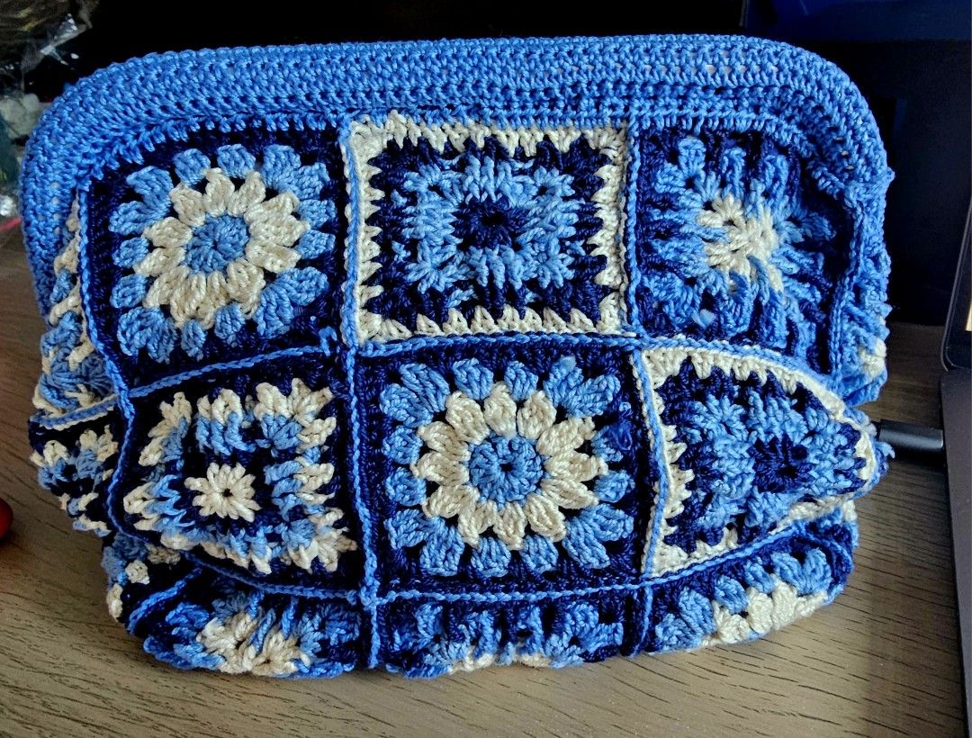 Handmade Crochet Clutch Bag - Blue (Category: Clutches) located in Makati City. Submitted by styledge.ph (Listing ID 1394874389, Image 3). Description: Handmade clutch bag features a beautiful crochet design in shades of blue and white. It has a rectangular shape with a frame closure. The bag is made of multiple crochet squares, creating a unique and stylish look. Perfect for carrying essentials, this clutch is a fashionable accessory for any occ