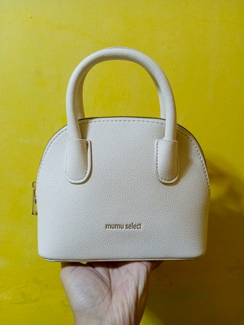 Mumu Select Dome Handbag - Beige White (Category: Luxury Bags & Wallets) located in Quezon City. Submitted by alibalza (Listing ID 1394951212, Image 1). Description: - Beige White-colored Mumu Select dome handbag - Top handle and detachable shoulder strap - Textured exterior - Gold-colored zipper and hardware - Brown interior lining - Includes dust bag RFS: not my style, used only once. MOP: Gcash, Maya, Maribank/Seabank 📍North Caloocan/Nova QC.