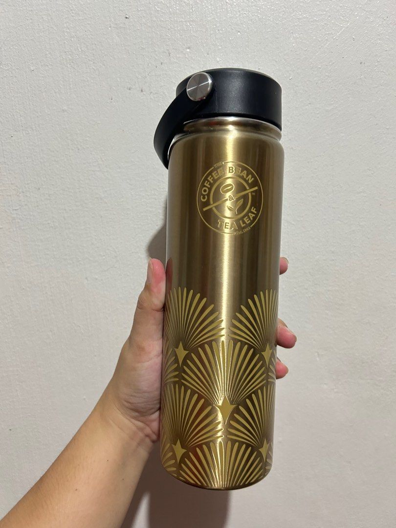 2022 CBTL Holiday your way Collection (Category: Water Bottles & Tumblers) located in Quezon City. Submitted by 47bea2b9d2c93d4bd094ba6042b4c6 (Listing ID 1395129667, Image 3). Description: - Gold-colored Coffee Bean & Tea Leaf tumbler - Black lid and handle - Decorative fan design - Comes with original box - Keeps drinks hot or cold - Stylish and practical.