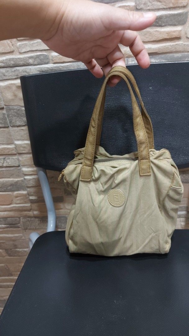 Fendi Tote Bag (Category: Luxury Bags & Wallets) located in Quezon City. Submitted by threetwotwo2ndaccount (Listing ID 1394975926, Image 1). Description: - Authentic Fendi tote bag - Beige exterior with brown handles - Secure zip closure - Stylish striped interior lining - Gold-colored zipper pull - Iconic round logo patch - Made from durable material issue: medyo malagkit ung handle as is .
