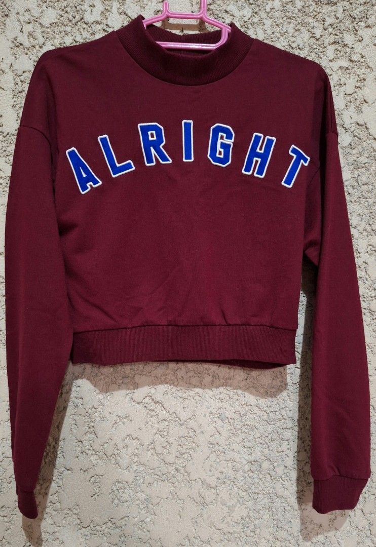 Forever 21 Alright Cropped Sweatshirt (Category: Longsleeves) located in Quezon City. Submitted by prelovedbox2016 (Listing ID 1395057575, Image 1). Description: - Forever 21 cropped sweatshirt - Color: Maroon - Graphic: "Alright" in blue and white - Features: Mock neck, long sleeves - Made in China.
