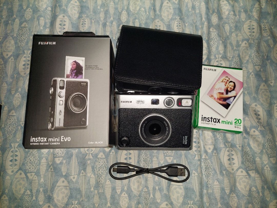 Fujifilm Instax Mini Evo Instant Camera (Category: Cameras) located in Manila. Submitted by mpxlive (Listing ID 1395021409, Image 1). Description: - Fujifilm Instax Mini Evo instant camera - Stylish silver and black design - Includes a black leather case - Comes with a charging cable - Original box included - Bought last June 6, 2025 - Used outside twice (company event and SHS Graduation); used a few times to print at home. Freebies: Free 20 Shee