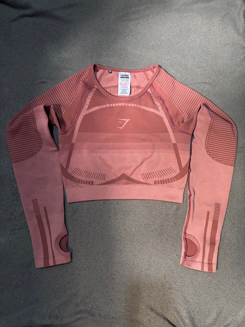 Gymshark Seamless Crop Top - Mauve (Category: Activewear) located in Caloocan City. Submitted by sherry_va (Listing ID 1394997393, Image 2). Description: - Gymshark seamless crop top - Color: Mauve - Size: Small - Features: Long sleeves with thumb holes, crew neck - Material: 54% nylon, 38% polyester, 8% elastane - Includes Gymshark logo.