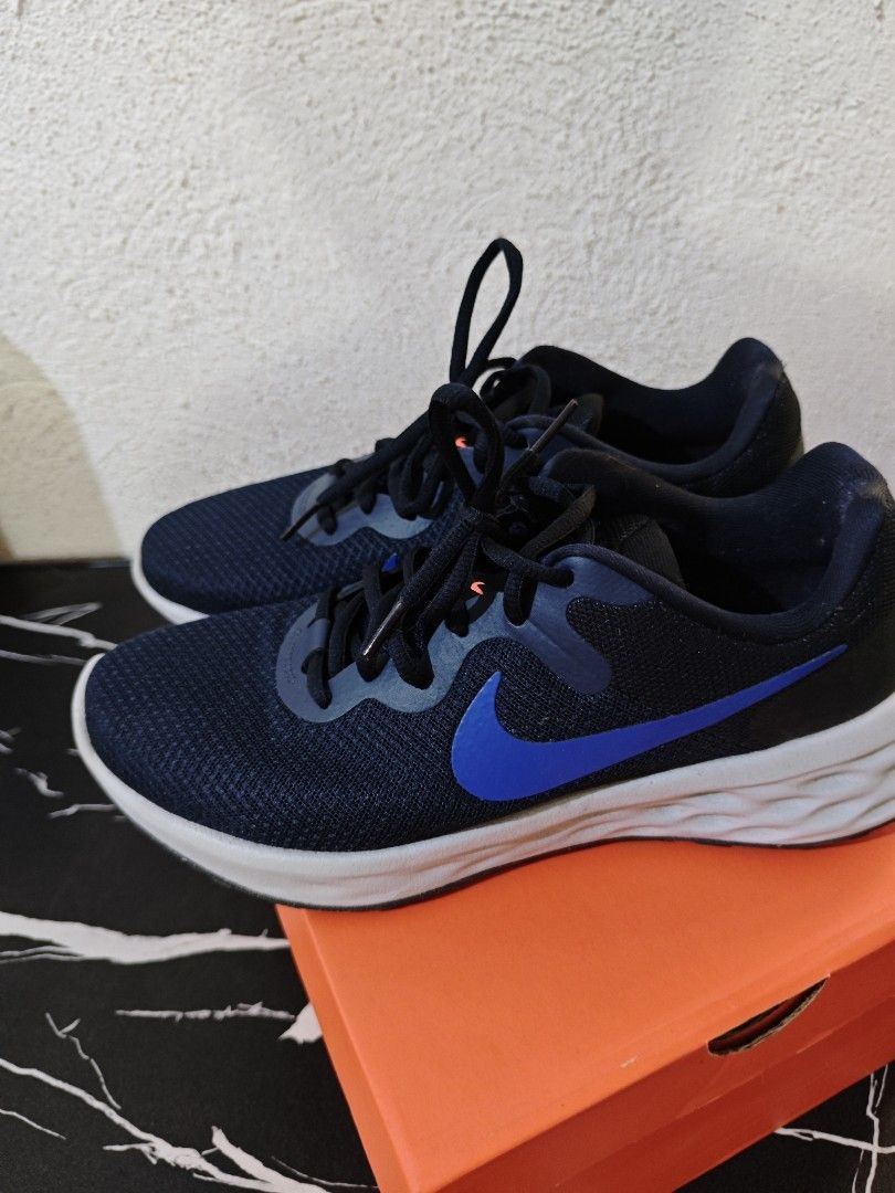 Nike Revolution 6 Running Shoes (Category: Activewear) located in Del Monte. Submitted by seleriii (Listing ID 1395027785, Image 2). Description: - Nike Revolution 6 running shoes - Color: Navy blue with white sole - Features blue Nike swoosh - Navy blue laces - Includes original orange box -size 8.5.