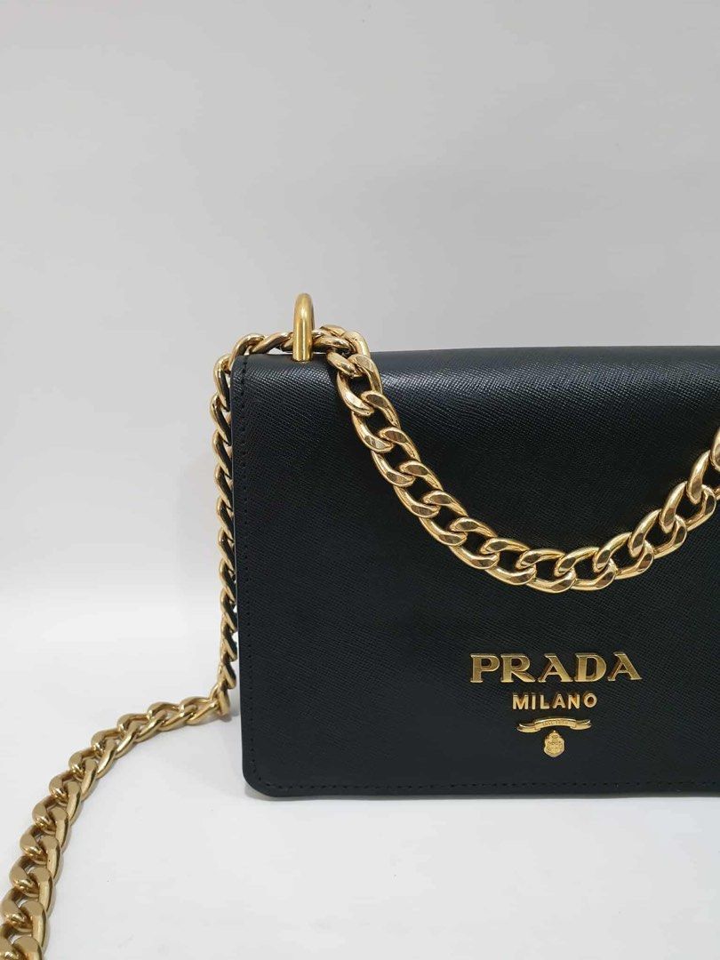 Prada Chain Crossbody Bag (Category: Luxury Bags & Wallets) located in Quezon City. Submitted by happy_shopperrr (Listing ID 1395101459, Image 3). Description: - Authentic Prada crossbody bag - Black leather exterior - Gold Prada logo - Gold chain strap - Flap closure - Contrasting blue and black color scheme - Compact and stylish design - Perfect for everyday or special occasions.