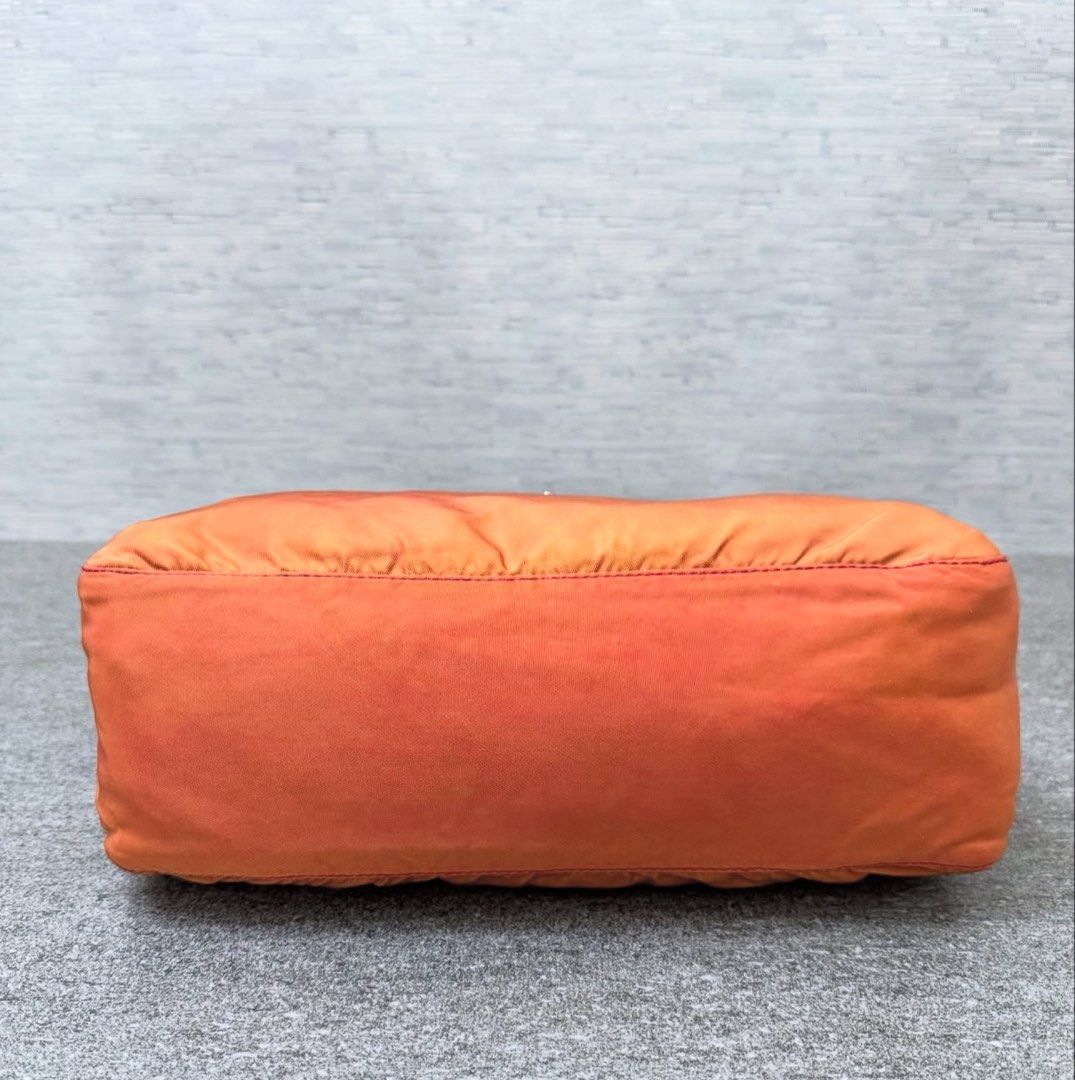 Prada Nylon Shoulder Bag (Category: Luxury Bags & Wallets) located in Quezon City. Submitted by happy_shopperrr (Listing ID 1395100330, Image 3). Description: - Prada shoulder bag - Orange nylon exterior - Red strap and trim - Prada-branded interior lining - Rectangular shape - Zip closure - Small Prada logo -with Entrupy Certificate.