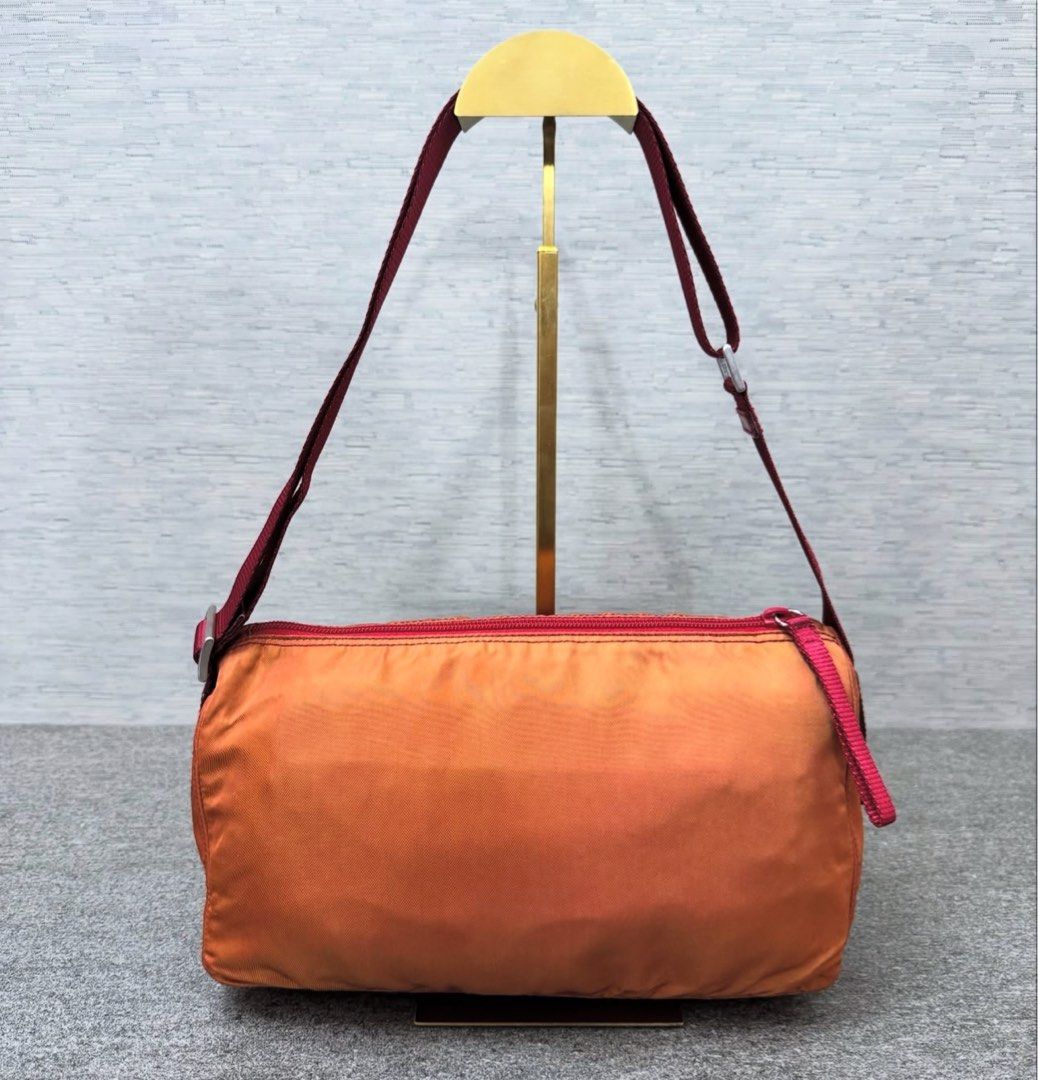 Prada Nylon Shoulder Bag (Category: Luxury Bags & Wallets) located in Quezon City. Submitted by happy_shopperrr (Listing ID 1395100330, Image 2). Description: - Prada shoulder bag - Orange nylon exterior - Red strap and trim - Prada-branded interior lining - Rectangular shape - Zip closure - Small Prada logo -with Entrupy Certificate.