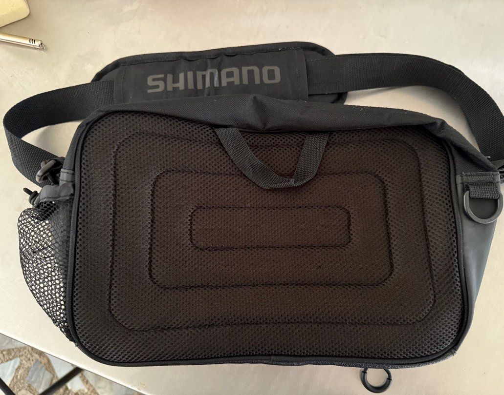 Shimano Fishing Shoulder Bag (Category: Shoulder Bags) located in Manila. Submitted by gentlewhale-d424 (Listing ID 1395037792, Image 2). Description: - Shimano shoulder bag - Multiple compartments - Vibrant blue interior - Padded shoulder strap for comfort - Mesh back panel for breathability - Small zippered pocket - Durable exterior - Shimano logo on strap and tag.