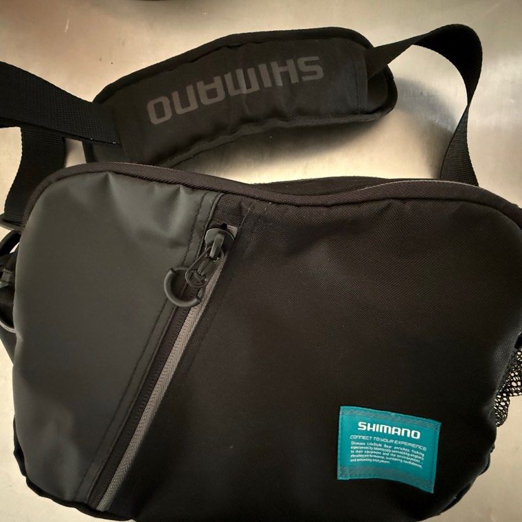 Shimano Fishing Shoulder Bag (Category: Shoulder Bags) located in Manila. Submitted by gentlewhale-d424 (Listing ID 1395037792, Image 1). Description: - Shimano shoulder bag - Multiple compartments - Vibrant blue interior - Padded shoulder strap for comfort - Mesh back panel for breathability - Small zippered pocket - Durable exterior - Shimano logo on strap and tag.