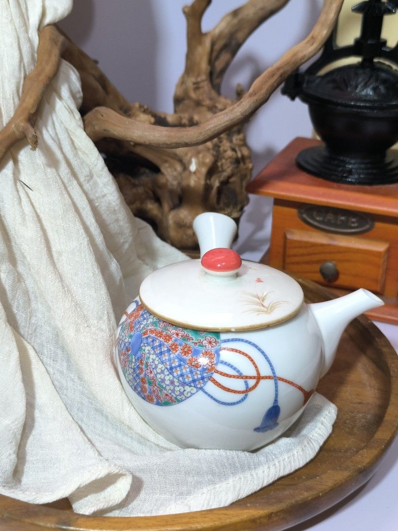 Vintage Japanese Ceramic Teapot (Category: Coffee & Tea Tableware) located in Pangil. Submitted by kopee_matcha (Listing ID 1395134509, Image 2). Description: - Vintage Japanese ceramic teapot - White body with colorful floral and geometric patterns - Red Orange knob on the lid - Features a side handle and spout .