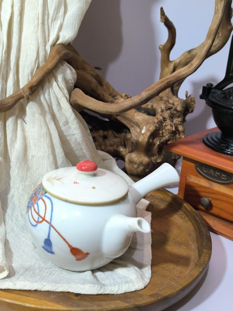 Vintage Japanese Ceramic Teapot (Category: Coffee & Tea Tableware) located in Pangil. Submitted by kopee_matcha (Listing ID 1395134509, Image 1). Description: - Vintage Japanese ceramic teapot - White body with colorful floral and geometric patterns - Red Orange knob on the lid - Features a side handle and spout .