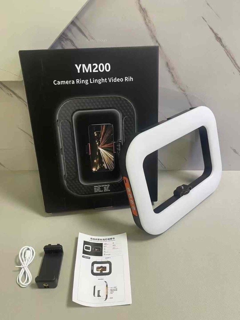 YM200 Handheld Rechargeable (8000mah)Ring Light (Category: Lighting & Studio Equipment) located in Manila. Submitted by iliasjen3082126 (Listing ID 1395130098, Image 1). Description: - YM200 Camera Ring Light for video recording - Includes: Ring light, phone holder, USB charging cable, user manual - Square-shaped ring light for bright illumination - Designed to hold your phone for easy recording - Box shows ring light with phone inside.