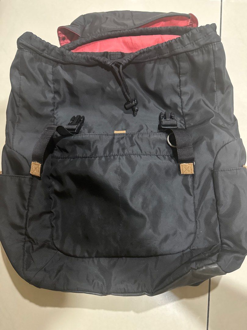 Black Drawstring Backpack (Category: Backpacks) located in Puchong. Submitted by king12396 (Listing ID 1395301285, Image 3). Description: - Black backpack - Drawstring closure - Adjustable straps - Red interior lining - Side pockets - Durable, possibly water-resistant material - Top flap with buckle closures - Padded back for comfort.