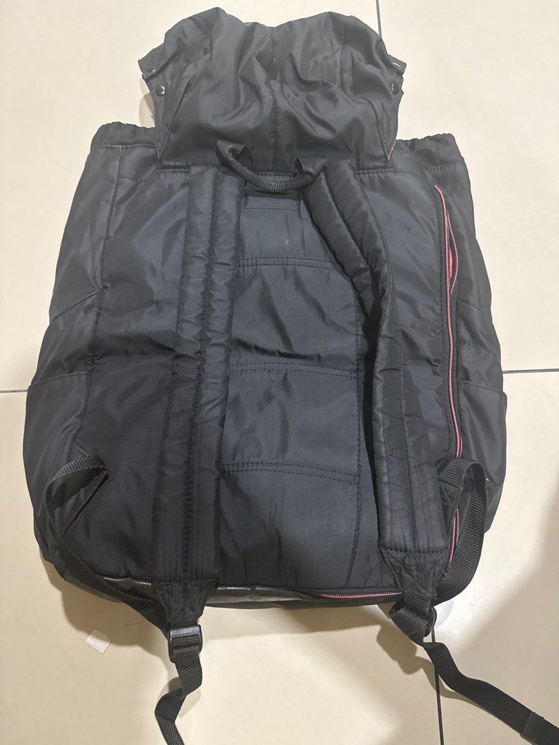 Black Drawstring Backpack (Category: Backpacks) located in Puchong. Submitted by king12396 (Listing ID 1395301285, Image 2). Description: - Black backpack - Drawstring closure - Adjustable straps - Red interior lining - Side pockets - Durable, possibly water-resistant material - Top flap with buckle closures - Padded back for comfort.