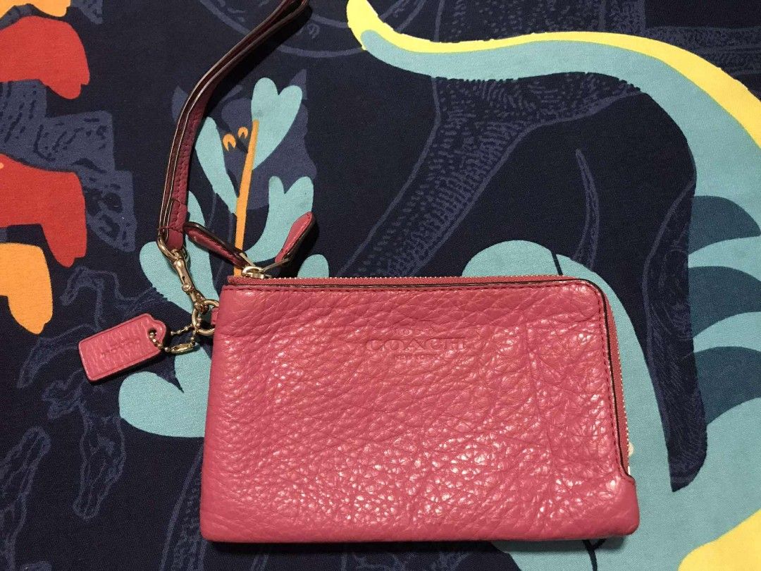 Coach Pink Wristlet (Category: Luxury Bags & Wallets) located in Tanza. Submitted by maryannrod99102 (Listing ID 1395171697, Image 1). Description: - Authentic Coach wristlet - Vibrant pink color - Textured leather exterior - Two zippered compartments - Interior card slots - Matching pink fabric lining - Gold-toned zippers - Includes wrist strap - Features a Coach tag -colors may vary due to lighting -issue nabakbak na ung leather sa loob sa gili