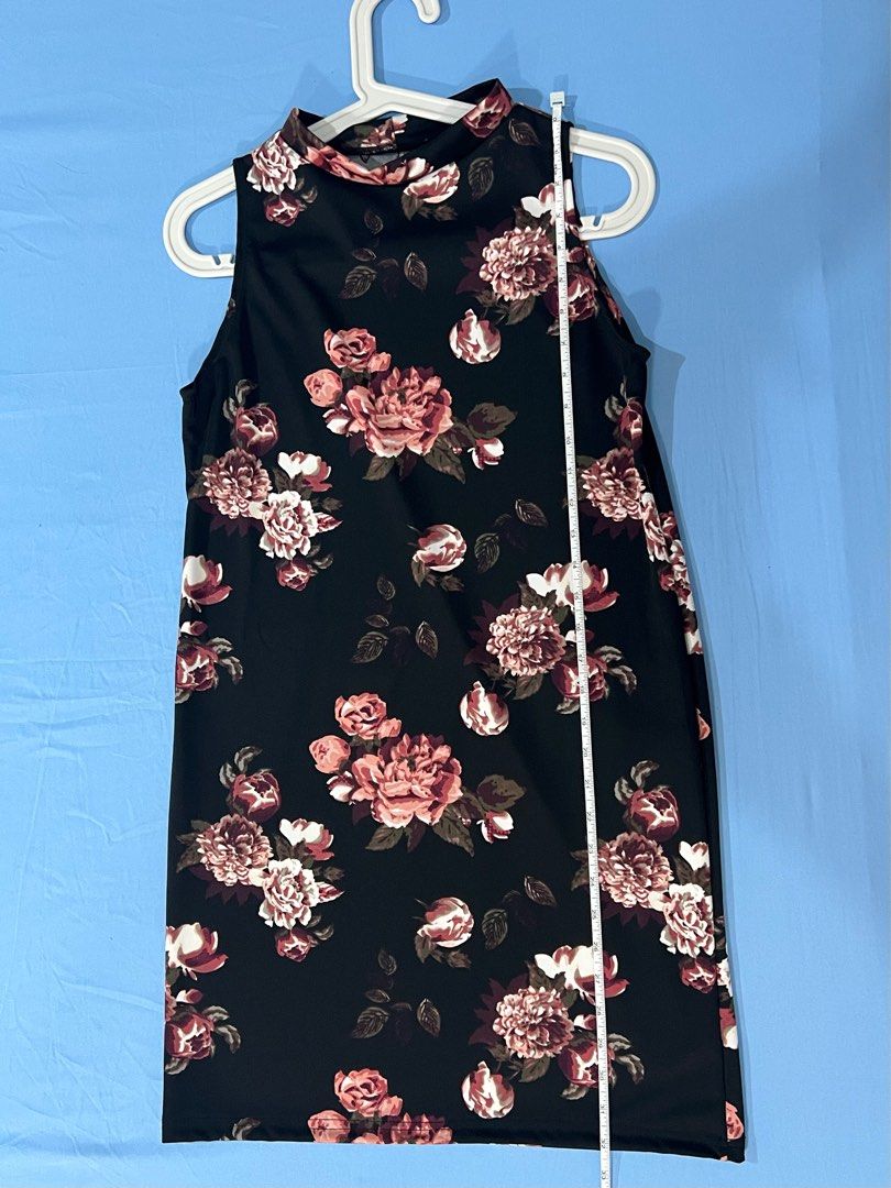 Floral Sleeveless Dress (Category: Dresses) located in Navotas City. Submitted by prelovedbyrtc (Listing ID 1395180903, Image 2). Description: - Black sleeveless dress - Floral pattern (pink and white flowers with green leaves) - High neckline - Knee-length - Smooth, likely synthetic fabric.