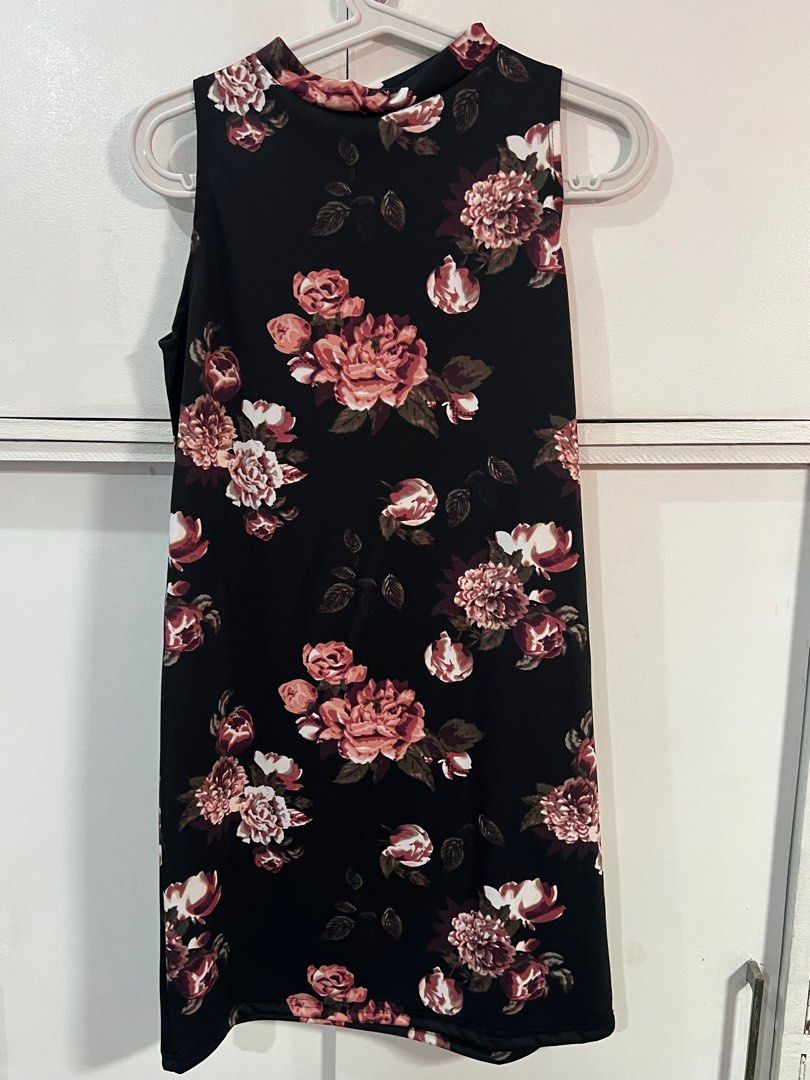 Floral Sleeveless Dress (Category: Dresses) located in Navotas City. Submitted by prelovedbyrtc (Listing ID 1395180903, Image 1). Description: - Black sleeveless dress - Floral pattern (pink and white flowers with green leaves) - High neckline - Knee-length - Smooth, likely synthetic fabric.