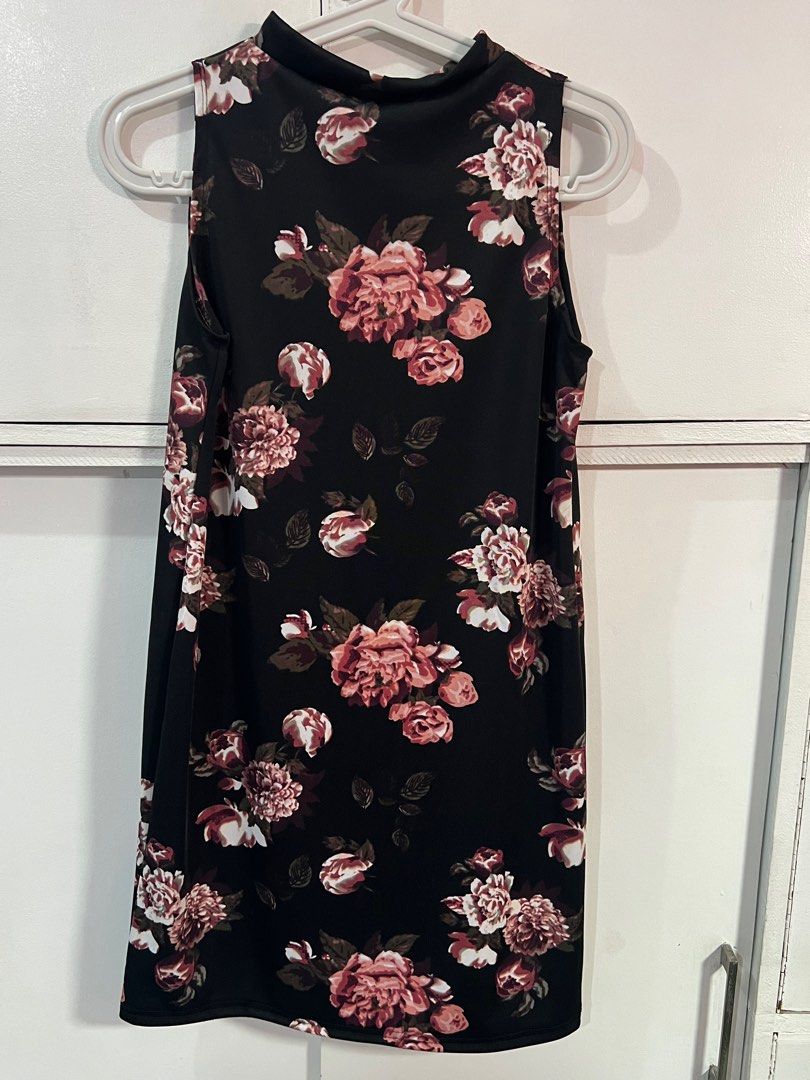 Floral Sleeveless Dress (Category: Dresses) located in Navotas City. Submitted by prelovedbyrtc (Listing ID 1395180903, Image 3). Description: - Black sleeveless dress - Floral pattern (pink and white flowers with green leaves) - High neckline - Knee-length - Smooth, likely synthetic fabric.