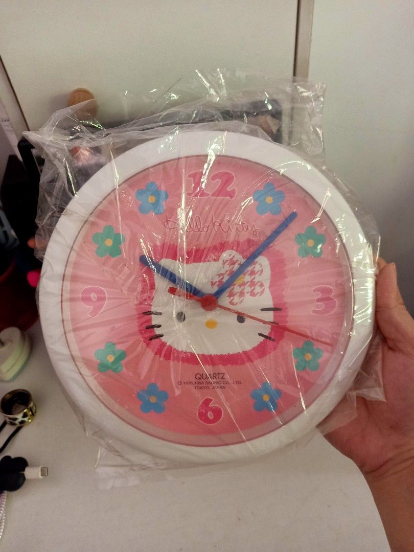Hello Kitty Quartz Wall Clock (Pink) (Category: Clocks) located in Bulacan. Submitted by baee__ (Listing ID 1395165343, Image 2). Description: - Kitty quartz wall clock - Features a pink face with Kitty design and floral accents - Brand new, in original packaging - White back - Includes original box - Hard to find .