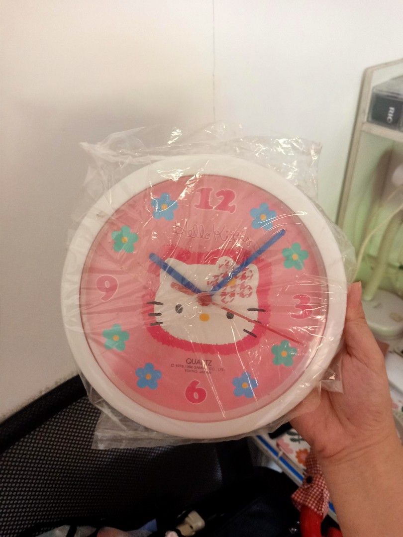 Hello Kitty Quartz Wall Clock (Pink) (Category: Clocks) located in Bulacan. Submitted by baee__ (Listing ID 1395165343, Image 1). Description: - Kitty quartz wall clock - Features a pink face with Kitty design and floral accents - Brand new, in original packaging - White back - Includes original box - Hard to find .