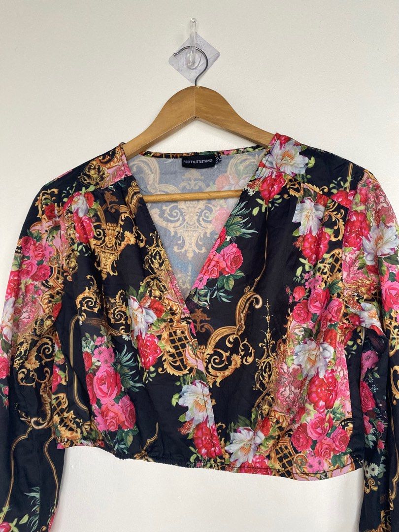 Black (Category: Blouses) located in Cavite. Submitted by jaydaascollection (Listing ID 1395253562, Image 1). Description: - PrettyLittleThing crop top - Features a flattering wrap style - Long sleeves and V-neckline - Eye-catching baroque and floral print - Colors: Black base with gold, pink, and red accents - Size Medium.