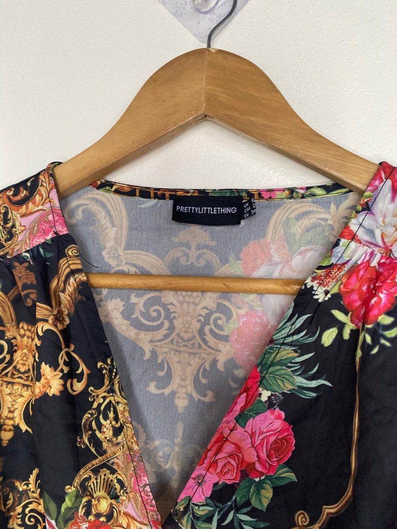 Black (Category: Blouses) located in Cavite. Submitted by jaydaascollection (Listing ID 1395253562, Image 3). Description: - PrettyLittleThing crop top - Features a flattering wrap style - Long sleeves and V-neckline - Eye-catching baroque and floral print - Colors: Black base with gold, pink, and red accents - Size Medium.