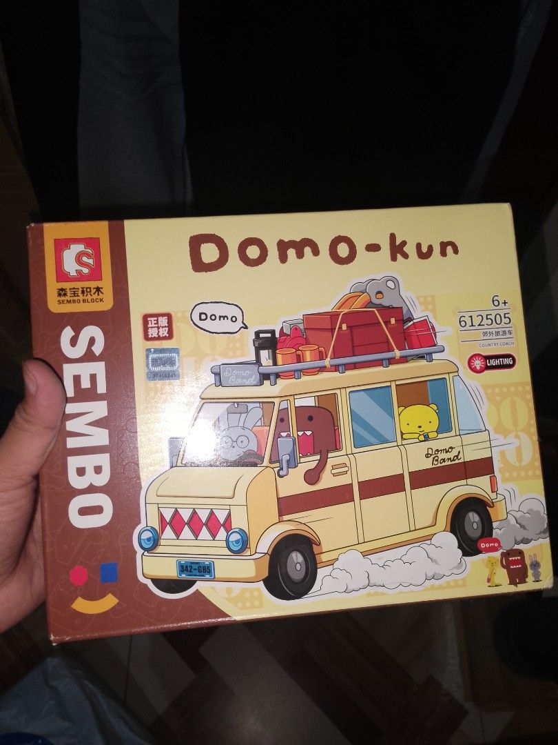 SEMBO Domo-kun Building Block Set (Category: Lego & Building Sets) located in Cainta. Submitted by mydailyell25316 (Listing ID 1395229922, Image 1). Description: - SEMBO building block set featuring Domo-kun in a van. - Includes Domo-kun figure and a yellow bear figure. - Box art shows the van with luggage..