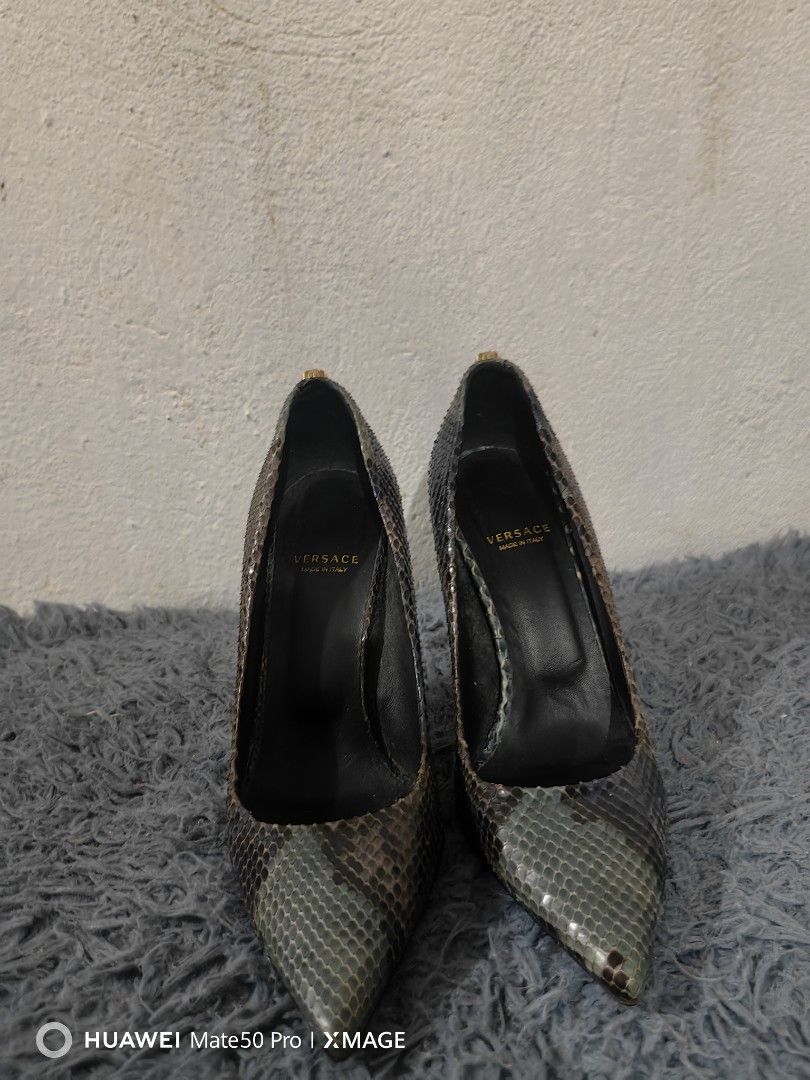 Versace Python Print Heels (Category: Sneakers & Footwear) located in Villasis. Submitted by mysticforest.bb2b4b (Listing ID 1395278474, Image 1). Description: Elegant Versace heels featuring a python print design. The heels have a pointed toe and a stiletto heel. The insole is black with the Versace logo and "Made in Italy" printed on it. The heels have a gold accent on the heel cap. The shoes appear to be made of leather..