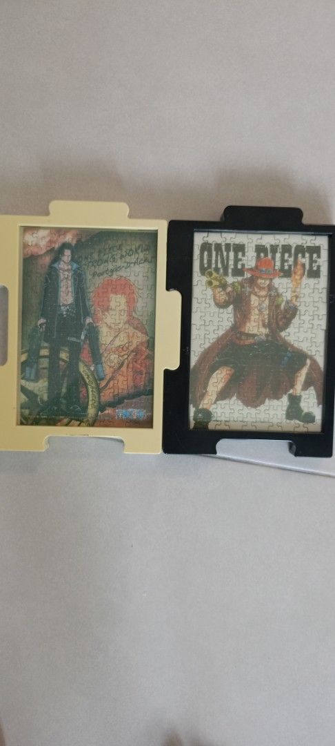 Ace One Piece Puzzle Set (Category: Toys & Games) located in Johor Bahru. Submitted by m.arifrahim (Listing ID 1395365880, Image 1). Description: - Two framed One Piece puzzles available. - Puzzle 1: Features a character with red hair. - Puzzle 2: Displays "ONE PIECE" with a character wearing a hat. - Both puzzles are framed. - Each frame includes a handle for easy carrying..