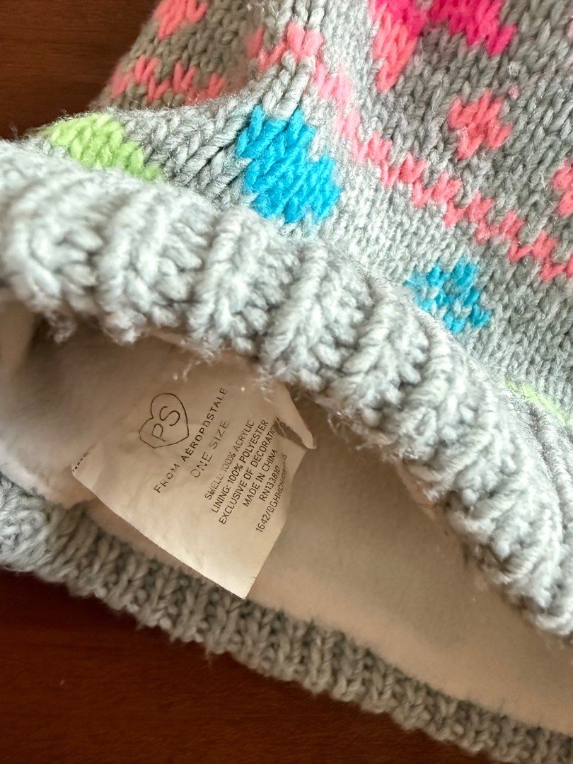 Aeropostale Knitted Beanie bonnet (Category: Babies & Kids Fashion) located in Makati City. Submitted by larcie (Listing ID 1395351958, Image 2). Description: - Aeropostale beanie - Colorful knit design: pink, blue, and green accents on a gray background - One size fits all - Soft lining - Material: 100% acrylic (main), polyester lining - think fabric - used in Japan winter .