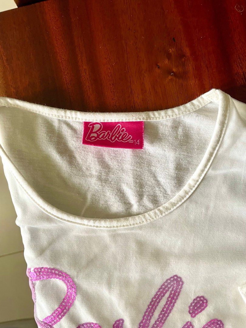 Barbie top for girls (Category: Babies & Kids Fashion) located in Taguig. Submitted by lam_decluttering (Listing ID 1395401046, Image 2). Description: Barbie white top size 14.