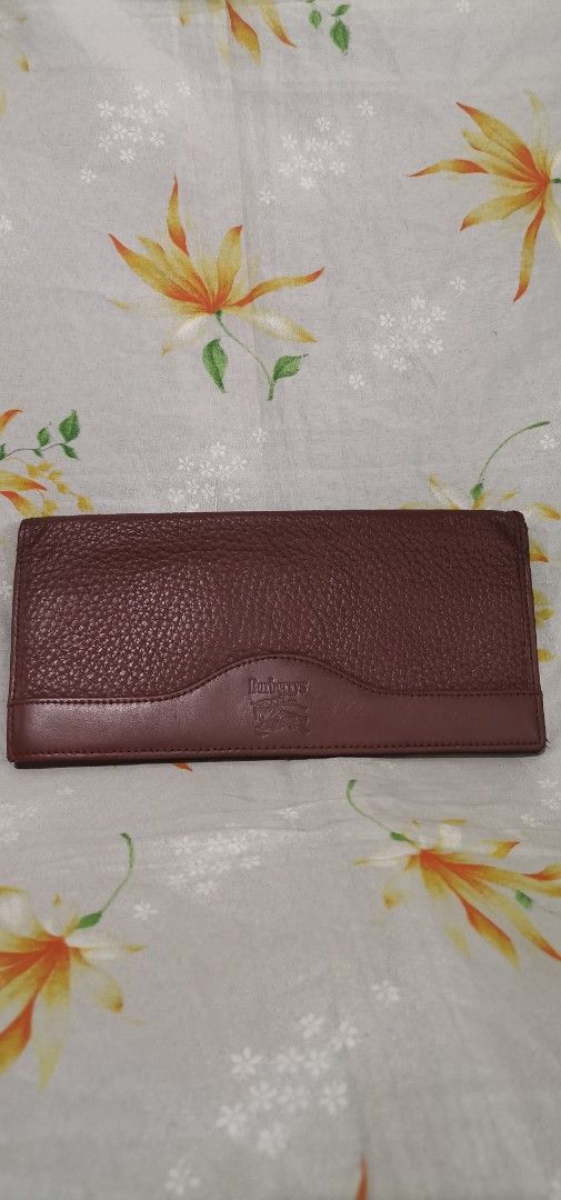 BURBERRYS Brown Leather Long Wallet (Category: Luxury Bags & Wallets) located in Baguio. Submitted by blossombeauty.chicfinds23 (Listing ID 1395418360, Image 1). Description: - Genuine Burberry wallet - Rich brown textured leather - Subtle Burberry logo embossing - Classic Burberry check interior lining - Multiple compartments for cards and cash - Stylish and functional design.