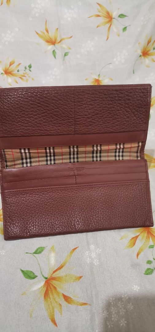 BURBERRYS Brown Leather Long Wallet (Category: Luxury Bags & Wallets) located in Baguio. Submitted by blossombeauty.chicfinds23 (Listing ID 1395418360, Image 3). Description: - Genuine Burberry wallet - Rich brown textured leather - Subtle Burberry logo embossing - Classic Burberry check interior lining - Multiple compartments for cards and cash - Stylish and functional design.