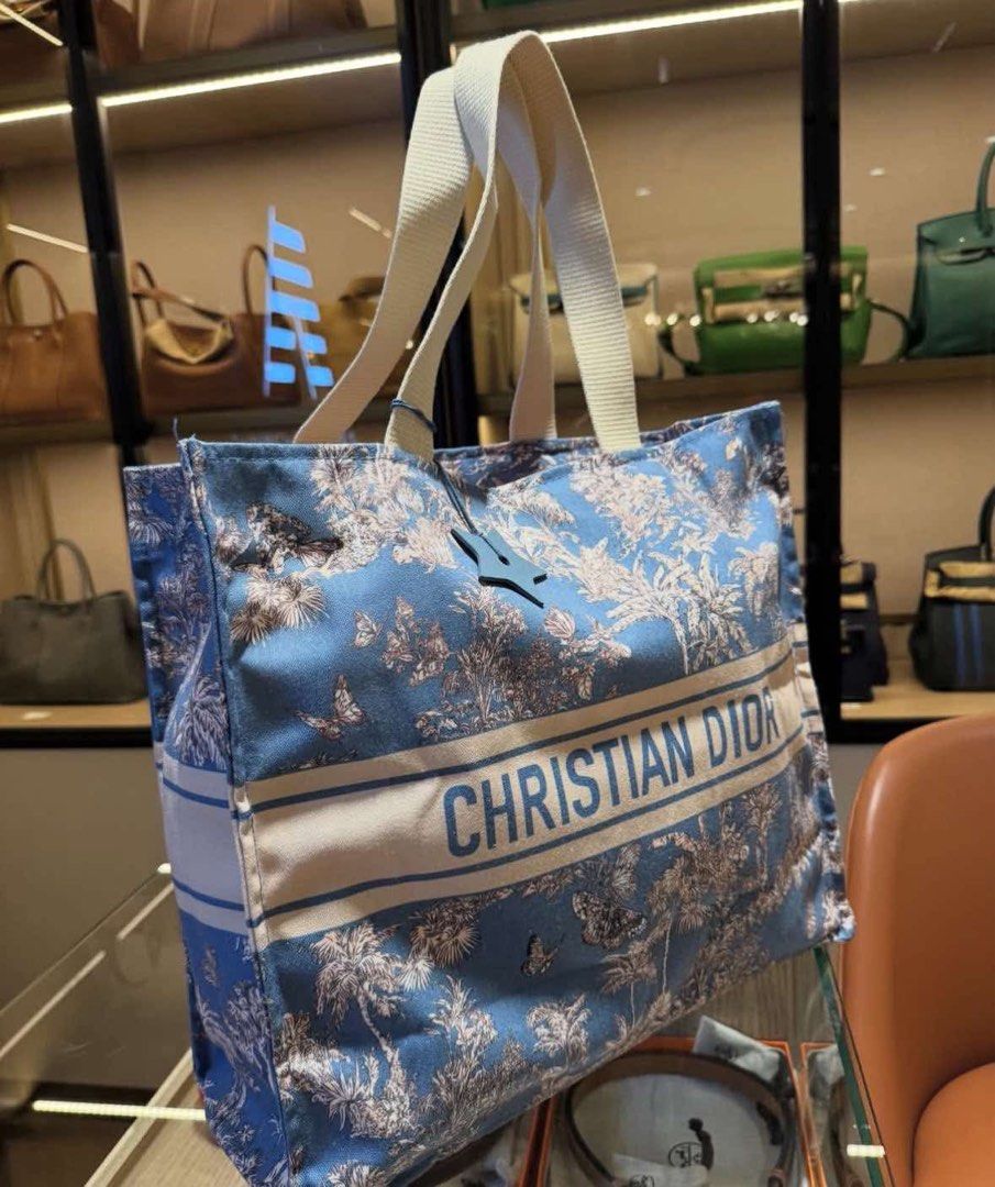 Christian Dior Blue Tote Bag (Category: Luxury Bags & Wallets) located in Manila. Submitted by coachphilippines__ (Listing ID 1395506234, Image 1). Description: - Christian Dior tote bag - Features a blue floral pattern - White stripe with brand name - White handles - Made of sturdy material - Perfect for everyday use.