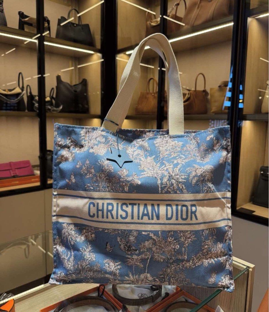 Christian Dior Blue Tote Bag (Category: Luxury Bags & Wallets) located in Manila. Submitted by coachphilippines__ (Listing ID 1395506234, Image 3). Description: - Christian Dior tote bag - Features a blue floral pattern - White stripe with brand name - White handles - Made of sturdy material - Perfect for everyday use.