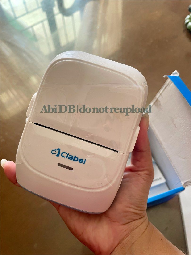 Clabel Label Printer (Category: Printers, Scanners & Copiers) located in Tagbilaran City. Submitted by abibi_declutter (Listing ID 1395364317, Image 3). Description: - Clabel Label Printer - Includes: Printer, User Manual, and a roll of white labels - Color: White and pastel blue - Features: Power button and Clabel logo - Condition: like new, in original box - Purpose: Designed for printing labels - RF: extra .
