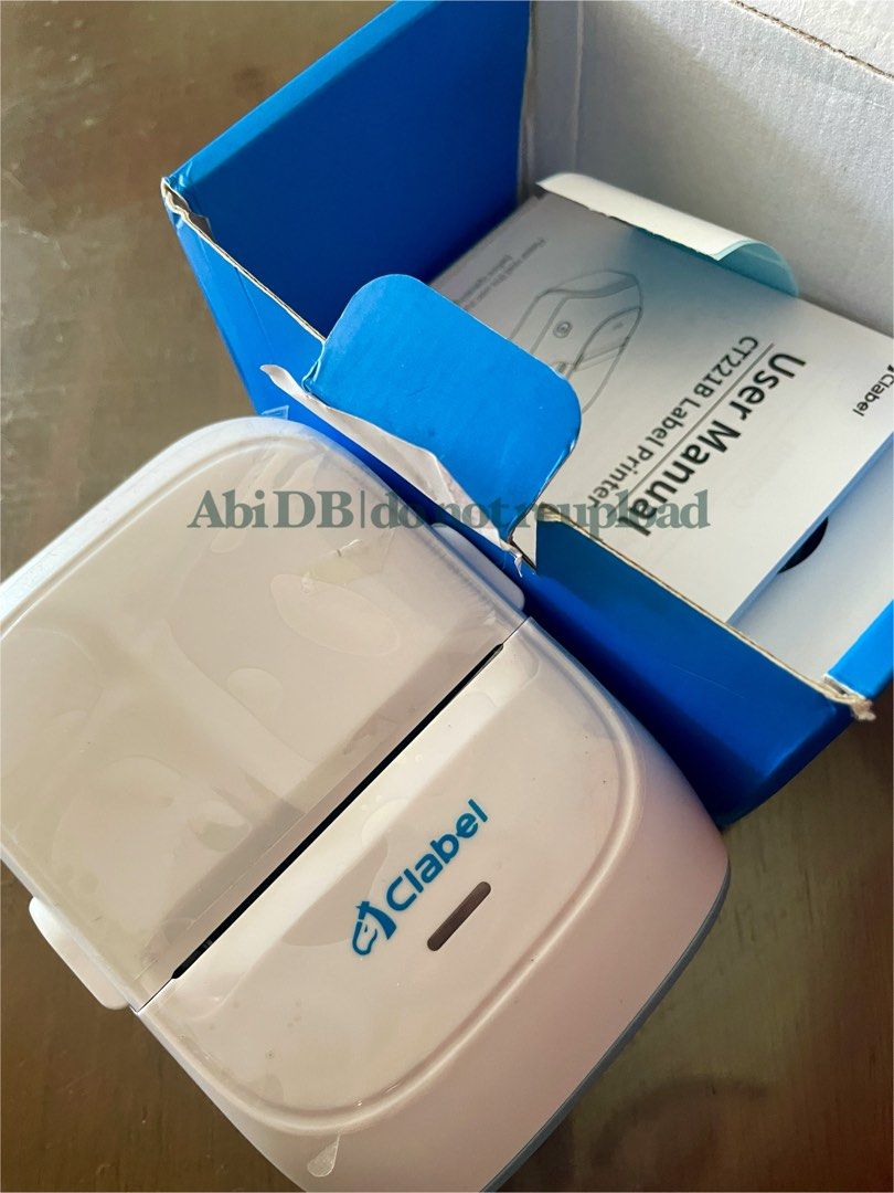 Clabel Label Printer (Category: Printers, Scanners & Copiers) located in Tagbilaran City. Submitted by abibi_declutter (Listing ID 1395364317, Image 2). Description: - Clabel Label Printer - Includes: Printer, User Manual, and a roll of white labels - Color: White and pastel blue - Features: Power button and Clabel logo - Condition: like new, in original box - Purpose: Designed for printing labels - RF: extra .