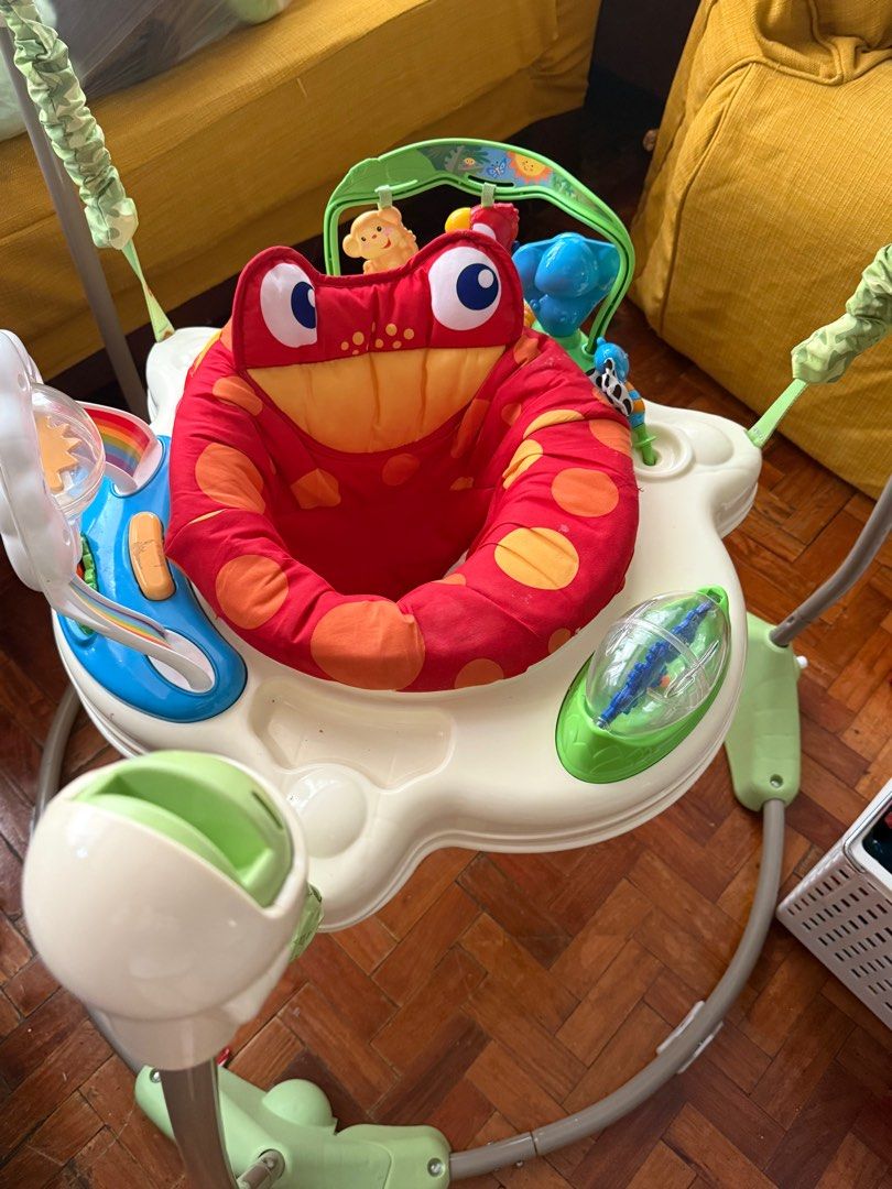 Fisher price jumperoo (Category: Babies & Kids Fashion) located in Pasig City. Submitted by atticfindsqc (Listing ID 1395352986, Image 1). Description: - Features a rotating seat for 360-degree access to toys. - Includes a toy bar with monkey and other colorful attachments. - Seat is red with orange polka dots. - Base is white and green..