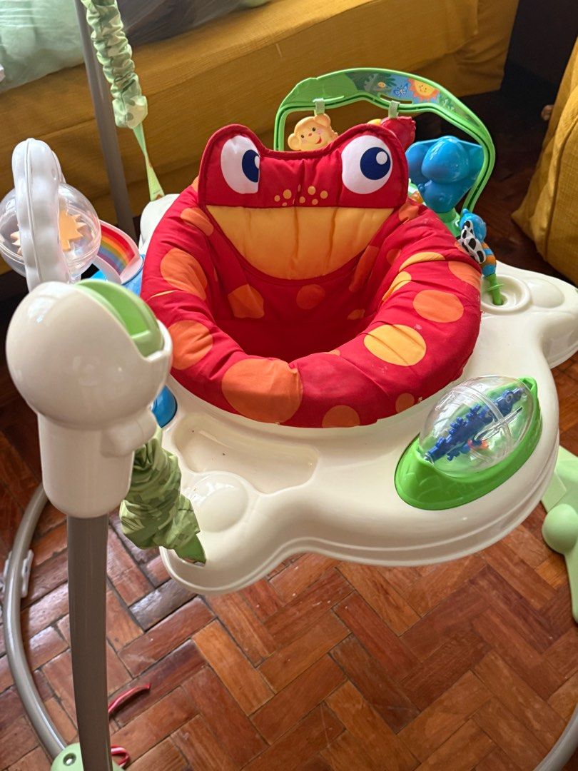Fisher price jumperoo (Category: Babies & Kids Fashion) located in Pasig City. Submitted by atticfindsqc (Listing ID 1395352986, Image 2). Description: - Features a rotating seat for 360-degree access to toys. - Includes a toy bar with monkey and other colorful attachments. - Seat is red with orange polka dots. - Base is white and green..
