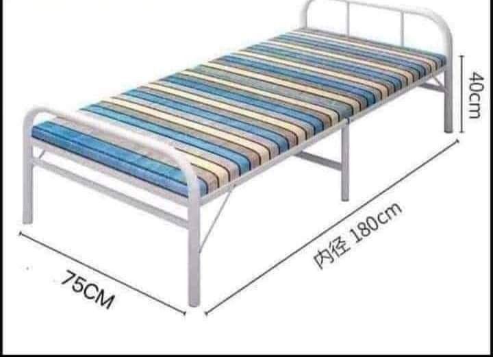 Folding Bed with Striped Mattress (Category: Bed Frames & Mattresses) located in Manila. Submitted by ncledlcrz (Listing ID 1395378180, Image 3). Description: - White metal frame folding bed - Mattress with blue and beige stripes - Dimensions: 180cm (length) x 75cm (width) x 40cm (height) - Foldable design for convenient storage - Ideal for small spaces and guest use.
