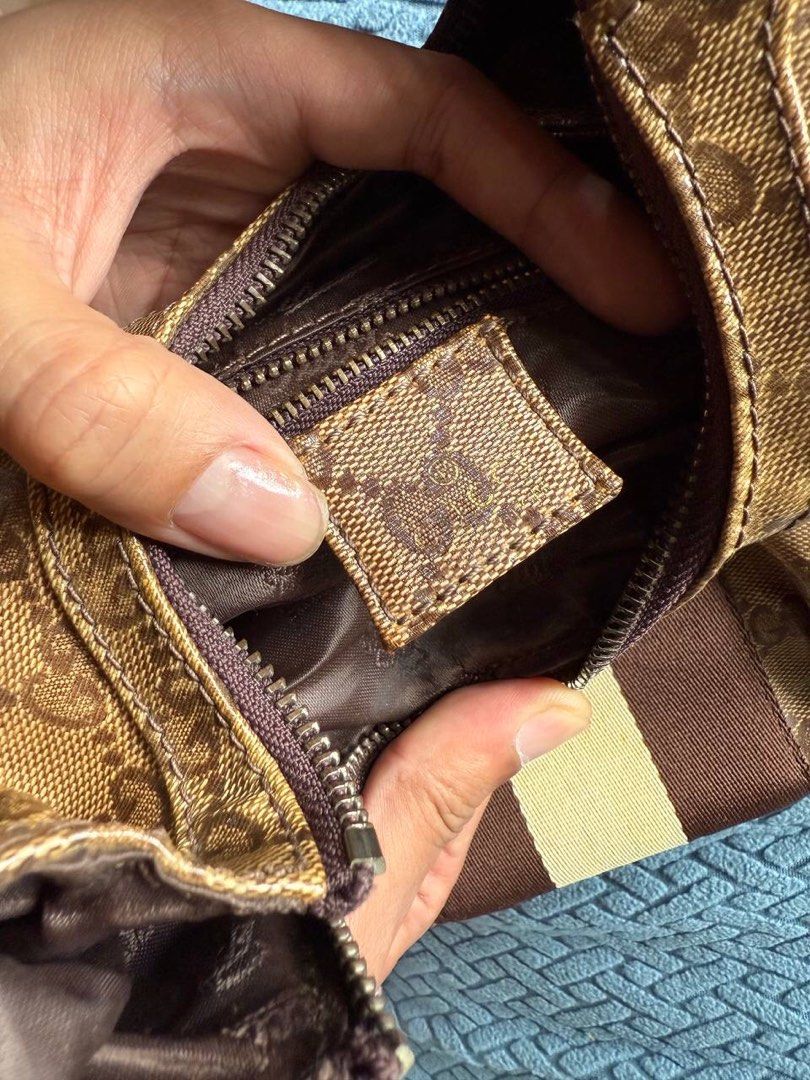 Gucci GG Crystal Canvas Stripe Hobo (Category: Luxury Bags & Wallets) located in Baguio. Submitted by BagstacularbyJCT (Listing ID 1395351270, Image 3). Description: This bag features the signature Gucci monogram in crystal canvas material. The exterior features a web stripe on the front, brass hardware, and two metallic charms dangling in the front. The interior can be accessed through a zip-top closure which opens to a zip-pocket and two slip-p