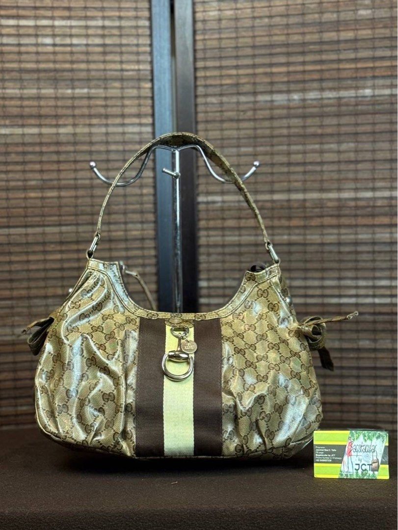 Gucci GG Crystal Canvas Stripe Hobo (Category: Luxury Bags & Wallets) located in Baguio. Submitted by BagstacularbyJCT (Listing ID 1395351270, Image 1). Description: This bag features the signature Gucci monogram in crystal canvas material. The exterior features a web stripe on the front, brass hardware, and two metallic charms dangling in the front. The interior can be accessed through a zip-top closure which opens to a zip-pocket and two slip-p